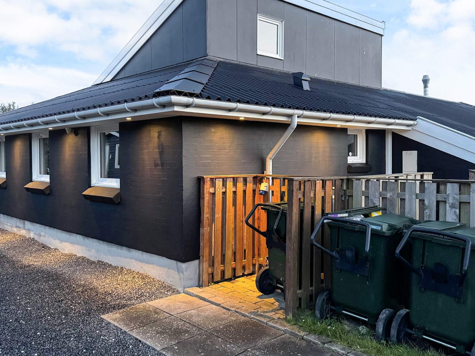 The entrance, with a screened store for bins and tools