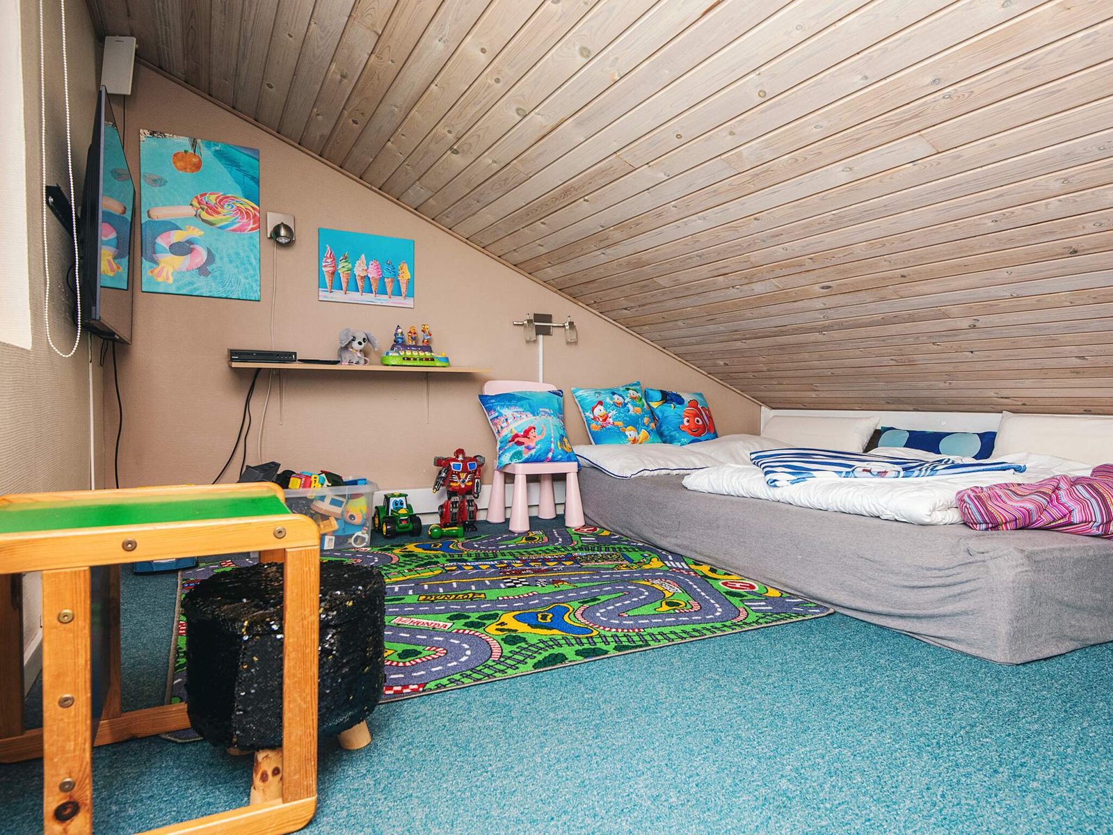 The loft laid out as a playroom, with mattress and television