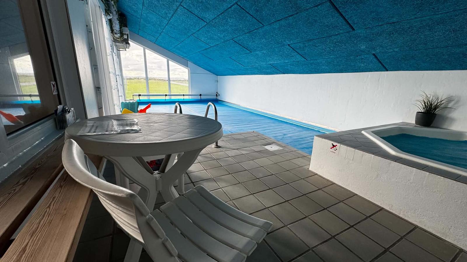 Bord og stol mellem poolen og whirlpoolen