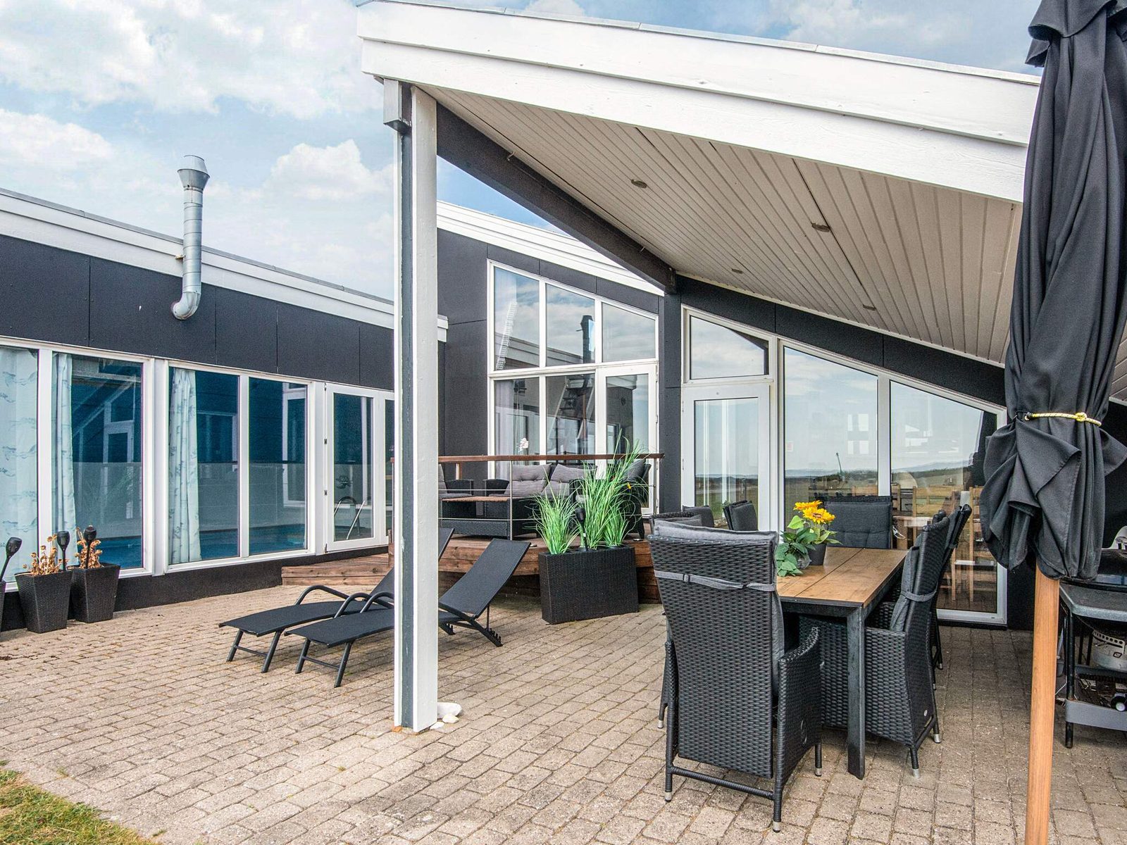 Covered terrace with dining table and sun loungers