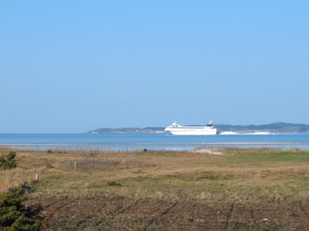A ferry passing off the coast below the house
