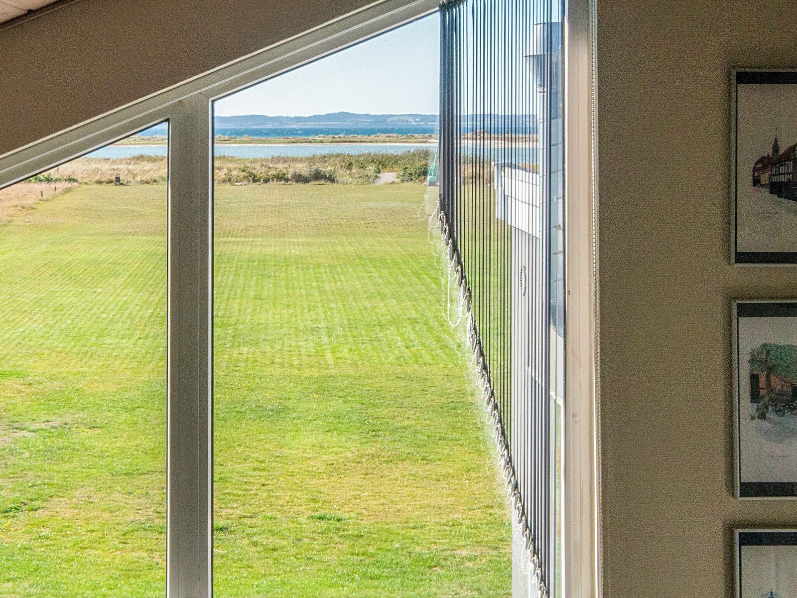 The living room window wall, looking across the field to the water